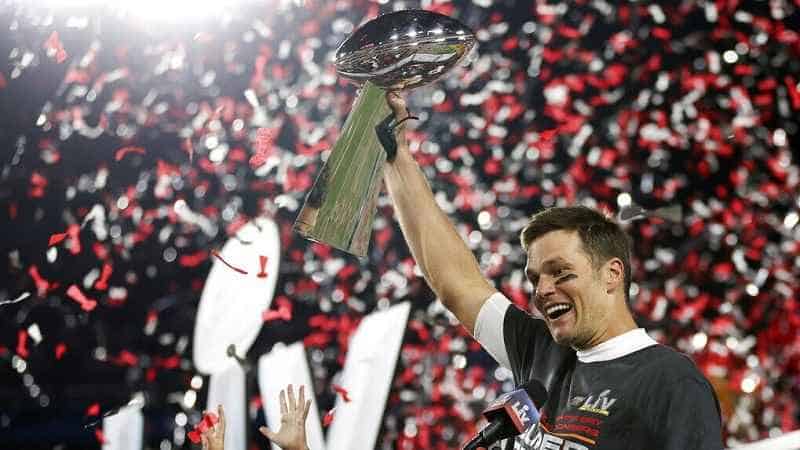 Tom Brady holding up Super Bowl trophy