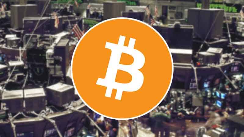 A Bitcoin icon over a stock market exchange floor